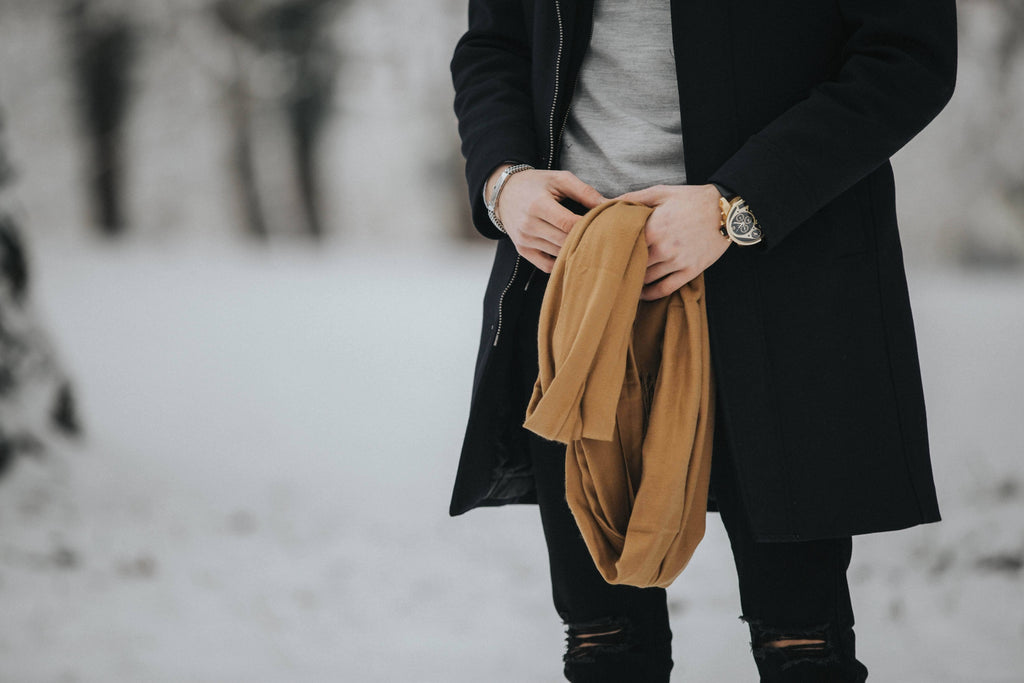 midsection stylish man holding his brown scarf standing outside black outfit